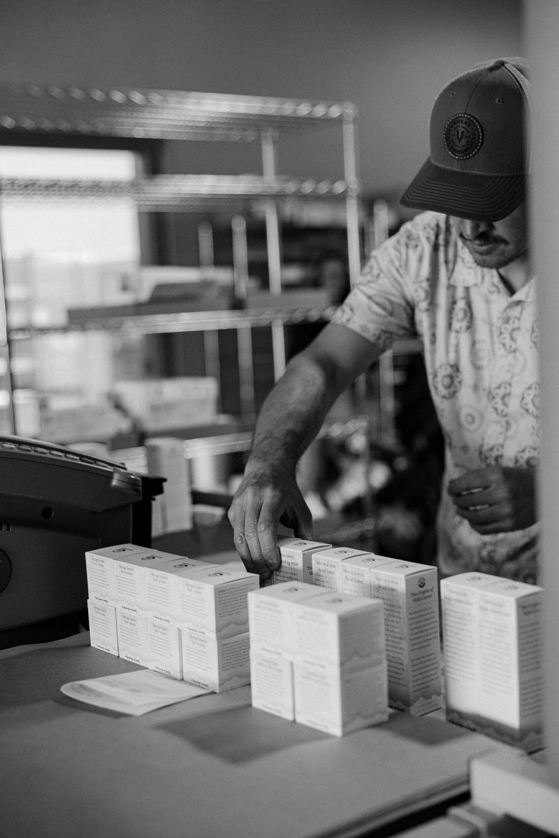 Person packaging boxes in a warehouse setting